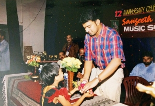 Stephen Devassy receiving boquet from child