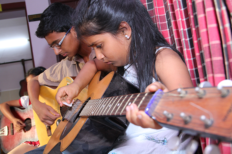 Students learning guitar